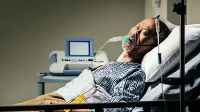 A sick man in a hospital bed.