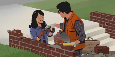 A couple uses mortar to lay bricks