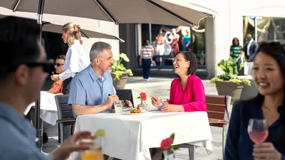 An older couple who are dating, chatting happily while enjoying a meal together at a restaurant.