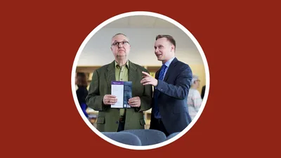 A brother with his Bible student at the Kingdom Hall, explaining what happens at Christian meetings.