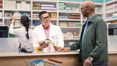The same older brother discussing the brochure “Enjoy Life Forever!” with a pharmacist.