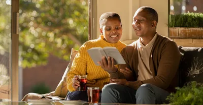 A married couple happily reading the Bible together.
