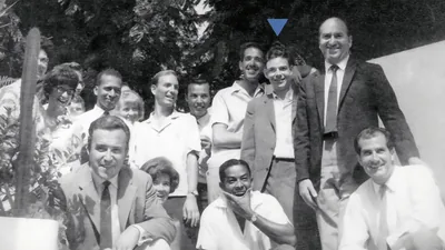 Brother Splane and a group of joyful brothers and sisters smiling for a photo.