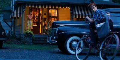 A reenactment of a young boy on a bicycle, cautiously looking over his shoulder while he delivers banned Bible literature in the 1940’s.