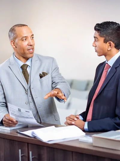 An elder training a young brother for a congregation assignment.
