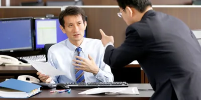 An employer shakes his finger at an employee