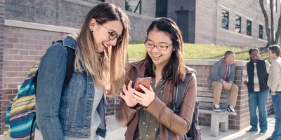 A young sister courageously witnessing to a classmate using her smartphone.