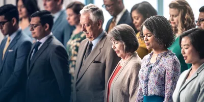 Brothers and sisters in a congregation bow their heads for a prayer