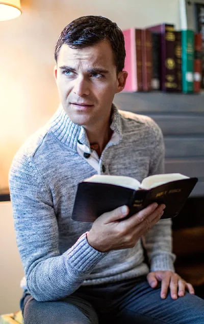 A man holds a Bible and looks skeptical