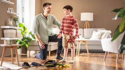 A father patiently listening to his young son as the boy explains how he accidentally broke a flower vase while playing with a toy plane.
