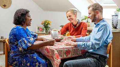 A young couple enjoying refreshments with an older sister at her home.